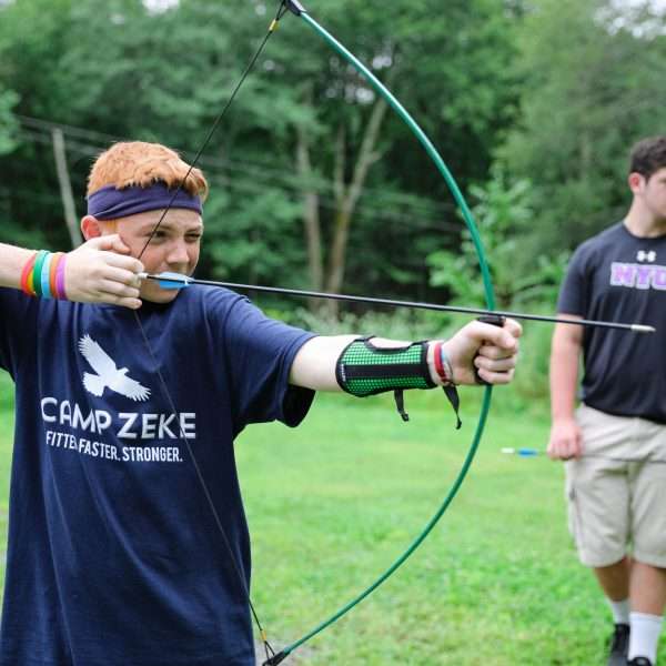 Male campers lining up a shot at archery