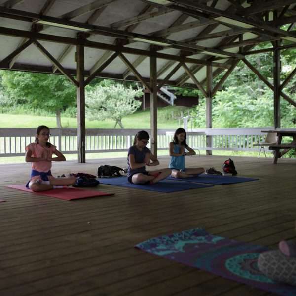 Campers doing Yoga in the covered pavillion