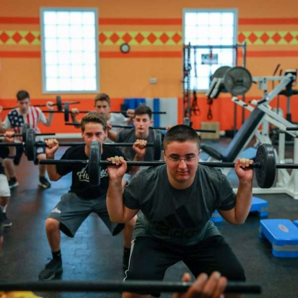 Group of campers lifting weights in the gym
