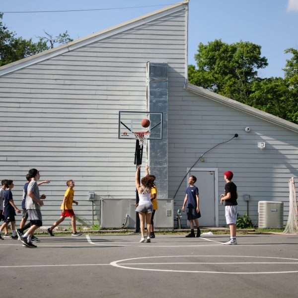 Group of campers playing basketball in the sun