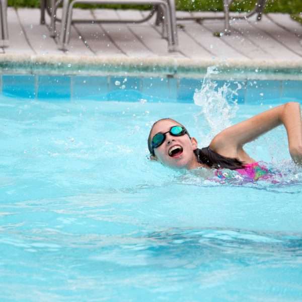 Female camper practising front crawl in the pool