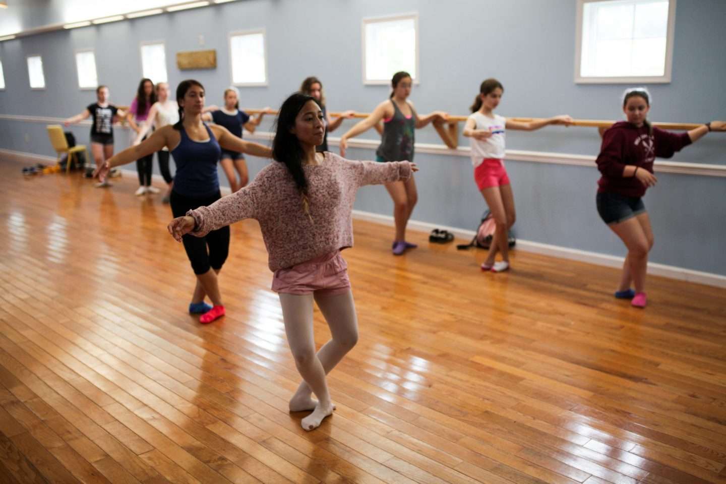 Group of female campers in the dance hall practising ballet