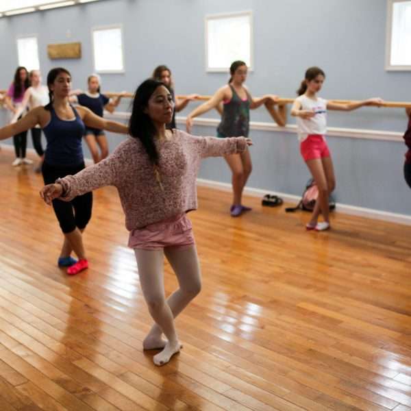 Group of female campers in the dance hall practising ballet