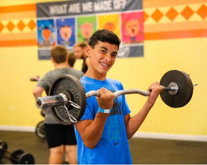 Camper lifting weights in the gym