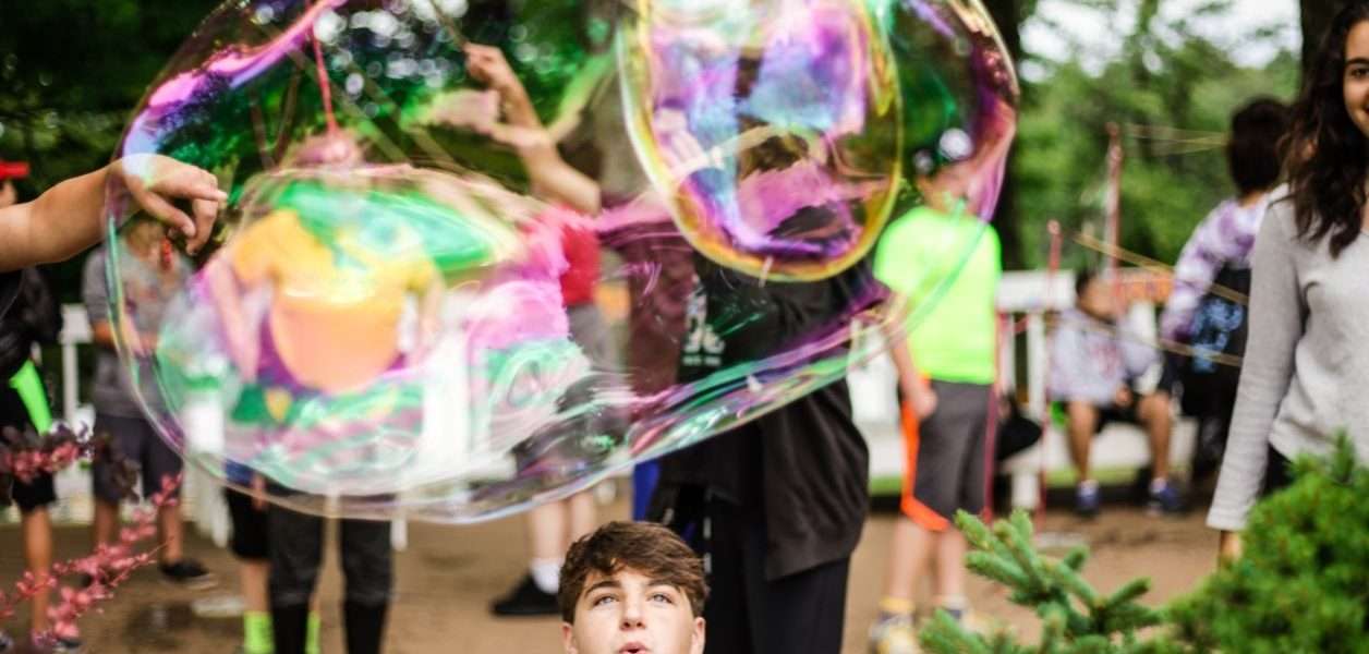 Campers blowing giant bubbles outside