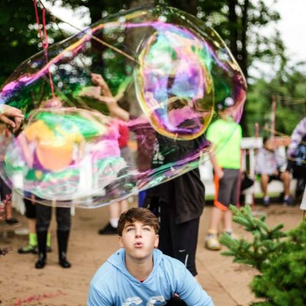 Campers blowing giant bubbles outside