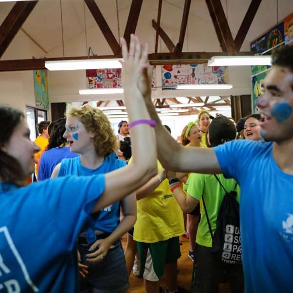 Two camp staff high-fiving each other