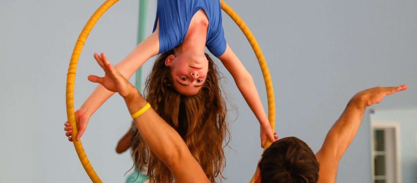 Female camper hanging from a suspended ring